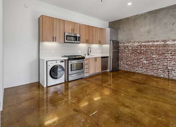 A kitchen with a refrigerator, oven, and microwave.