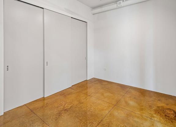 A room with a brown floor and white walls.