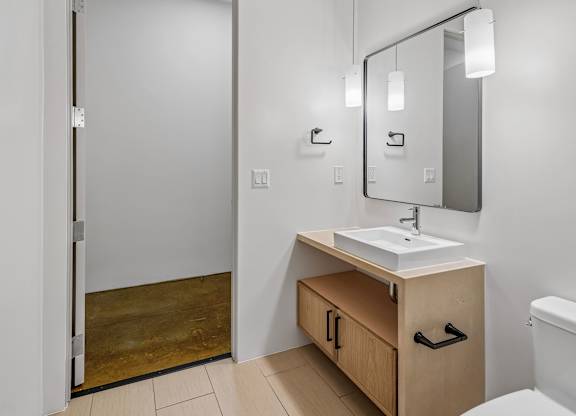 A bathroom with a sink, mirror, and toilet.