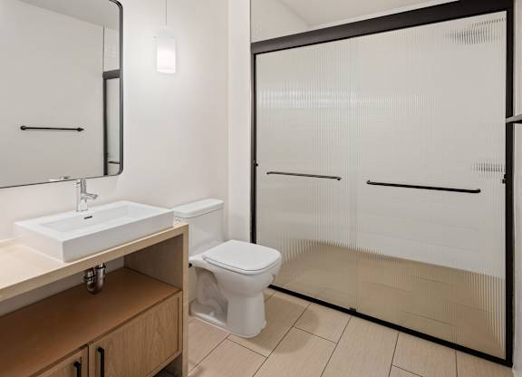 A white toilet sits in a bathroom next to a sink.