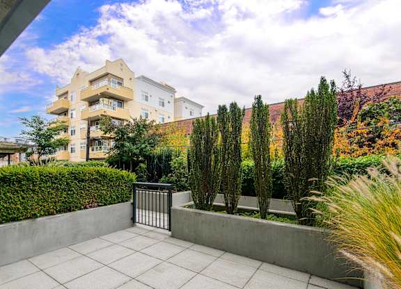 Private patio with concrete planters and landscaping at Axis Seattle Apartments, Seattle, Washington