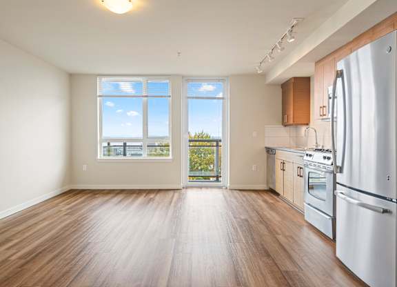 Open floor plan with kitchen and balcony access at Axis Seattle Apartments, Seattle, Washington
