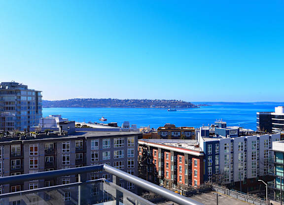 Waterfront view from balcony overlooking city buildings at Axis Seattle Apartments, Seattle, 98109