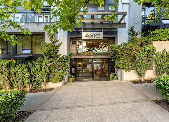 Property entrance with modern canopy and landscaping at Axis Seattle Apartments, Seattle