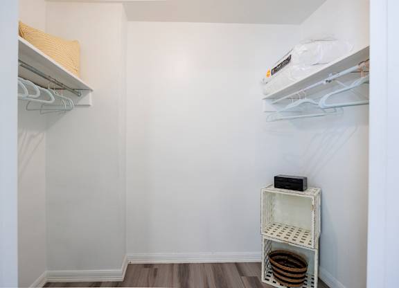 A small white closet with a shelf and a hanging rod.