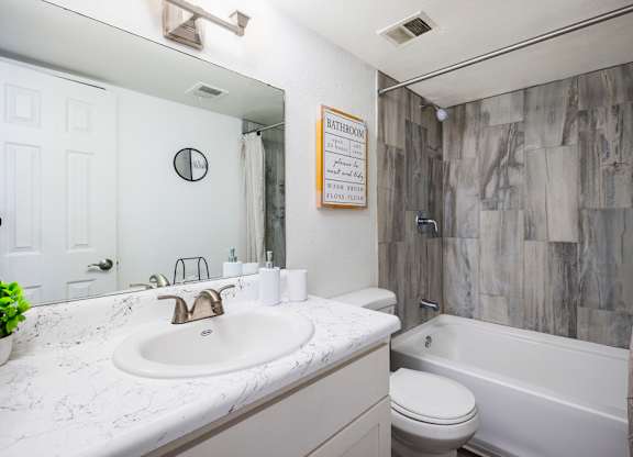 A bathroom with a white sink and a white toilet.
