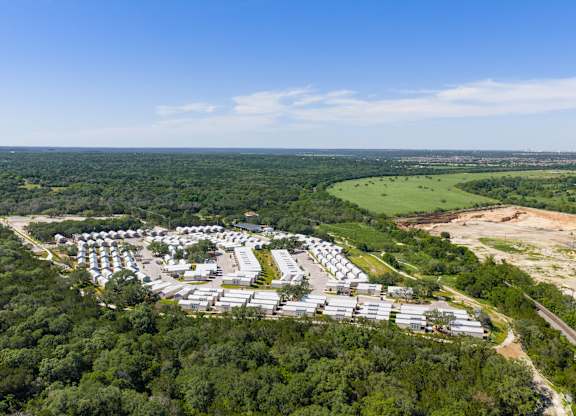 A bird's eye view of a residential area surrounded by greenery.
