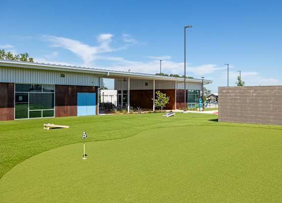 A golf course with a green and a flag on the hole.