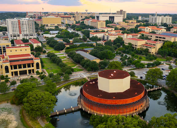 A large building with a red and white dome sits in the middle of a body of water.