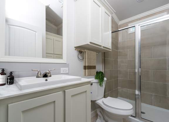 A bathroom with a toilet, sink, and shower.
