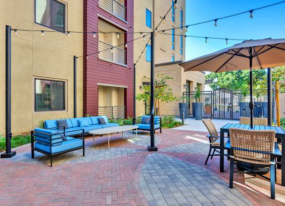 A patio with a blue sofa and chairs.