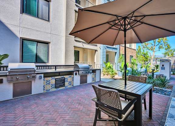 A patio with a table and chairs under an umbrella.
