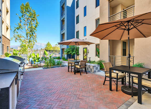 A patio with a table and chairs and an umbrella.