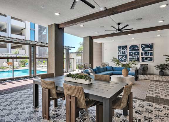 A modern dining room with a pool in the background.
