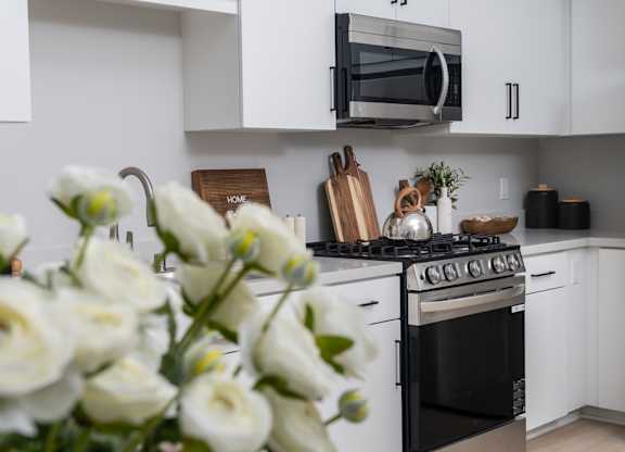 A kitchen with a black stove and white cabinets.