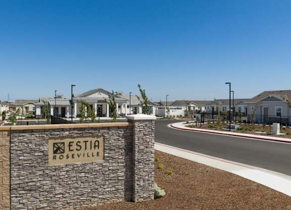 A stone wall with a sign that says Estia Roseville.