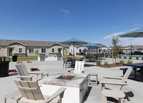 A patio with chairs and a fire pit.