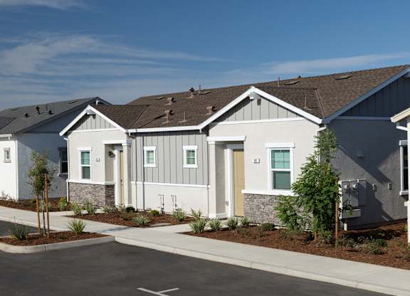 A row of modern houses with a clear blue sky above them.