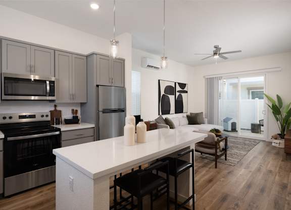A modern kitchen with a white island and stainless steel appliances.