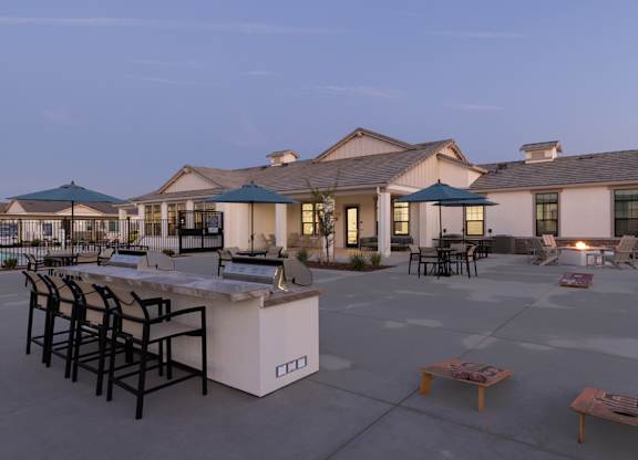 A large building with a patio area in front of it.