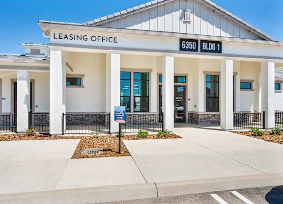 A white building with a sign that says Leasing Office.