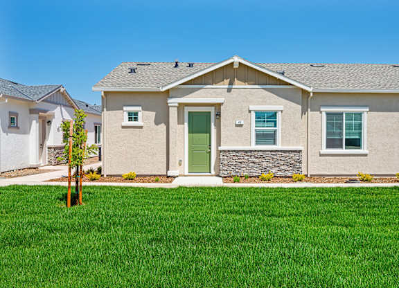 A house with a green lawn in front.