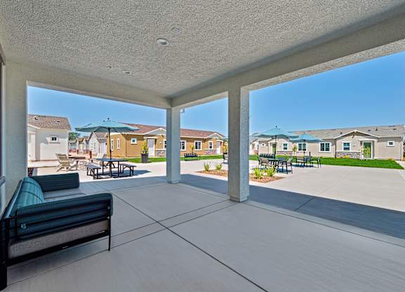 A patio with a bench and a view of a residential area.