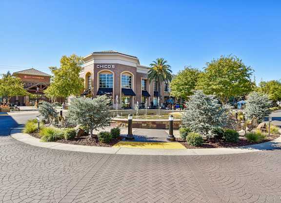 A Chick-fil-A restaurant is surrounded by palm trees and other greenery.