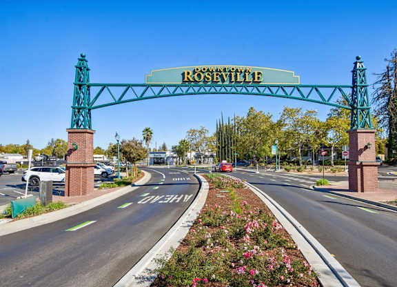 A street view of a roseville street with a green archway.