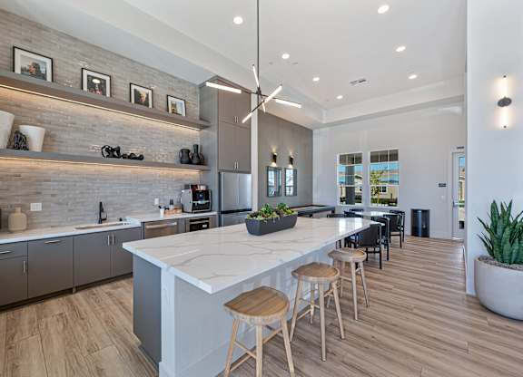 A modern kitchen with a large island and wooden floors.