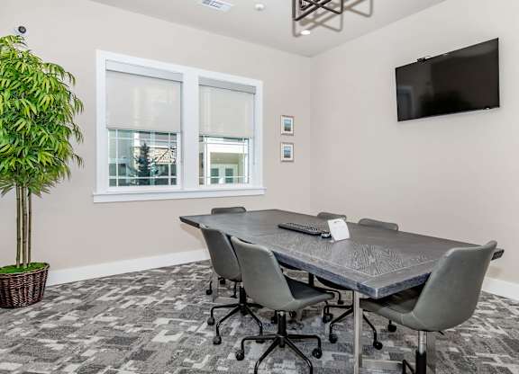 A conference room with a large table and chairs.