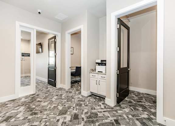 A hallway with a patterned floor and white walls.