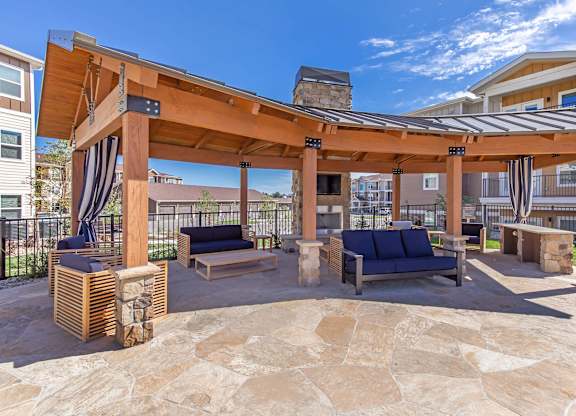 A patio with a pergola and couches.