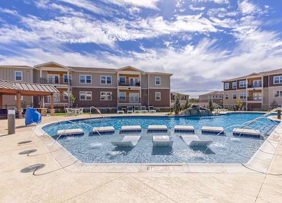 A swimming pool in front of apartment buildings.