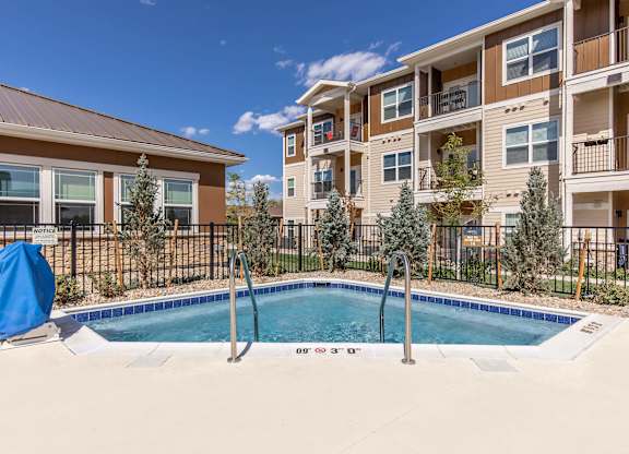 A pool in front of a building with a blue chair.