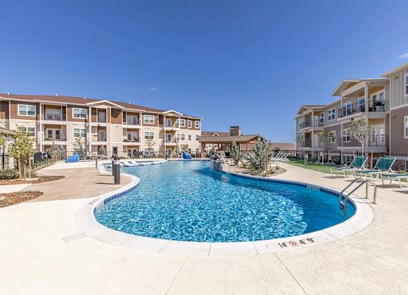 A swimming pool in front of apartment buildings.