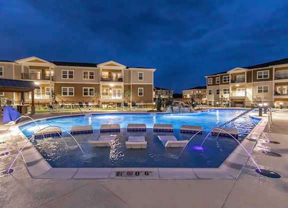 A large outdoor pool with a fountain in the middle of it.