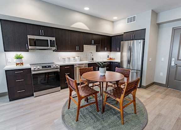 Eat-In Kitchen With Dining Room Table, Black Cabinets, White Countertops, And Stainless-Steel Appliances. at Bayswater Apartments, Burlingame