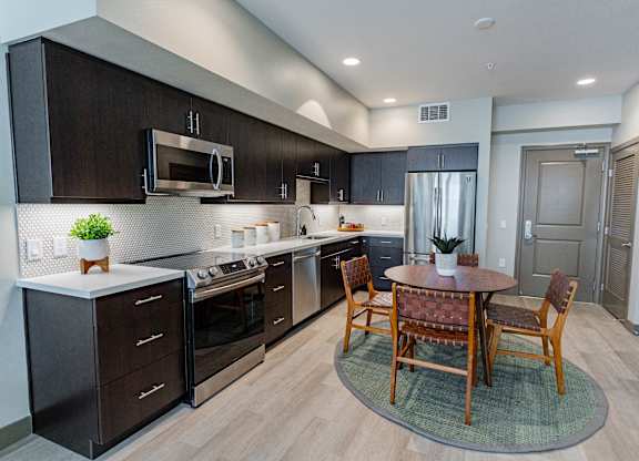 Eat-In Kitchen With Dining Room Table, Black Cabinets, White Countertops, And Stainless-Steel Appliances. at Bayswater Apartments, Burlingame, 94010