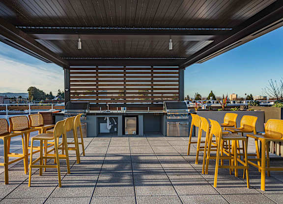 Rooftop Grill Area With Wood-Style Seating, City Views, And Gazebo-Style Covering. at Bayswater Apartments, Burlingame, CA