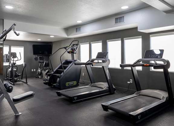 A gym with treadmills, elliptical machines, and other exercise equipment at Verandas Apartments, West Covina, California