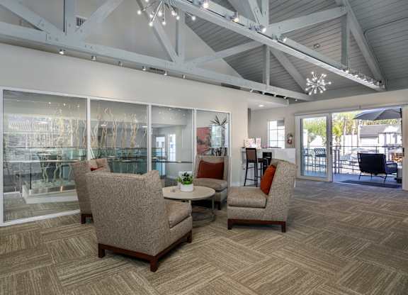 A room with a table and chairs and a glass wall at Verandas Apartments, California