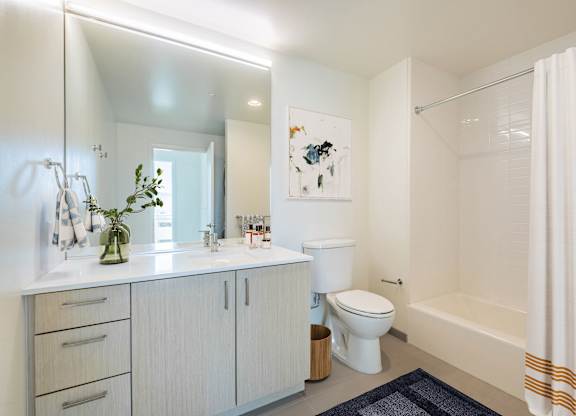 A white bathroom with a toilet, sink, and bathtub.