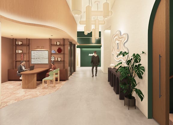 A hallway with a person walking down it and a green door at the end.