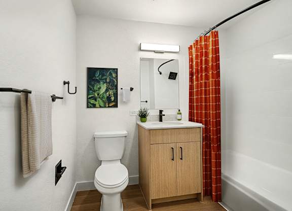 A small bathroom with a toilet, sink and a shower curtain.