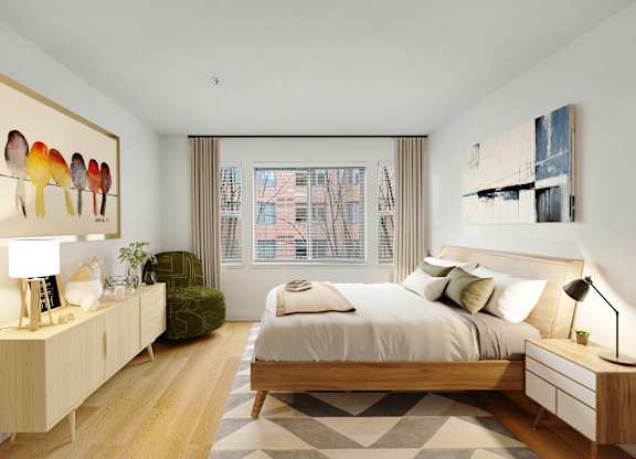 A bedroom with a large bed, a green chair, and a painting on the wall.