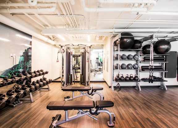 A gym with a variety of equipment including weights and a bench.at The Rise, California, 94103