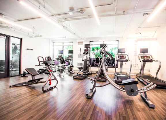 A gym with a variety of equipment including treadmills, stationary bikes, and weight machines.at The Rise, San Francisco, 94103  
