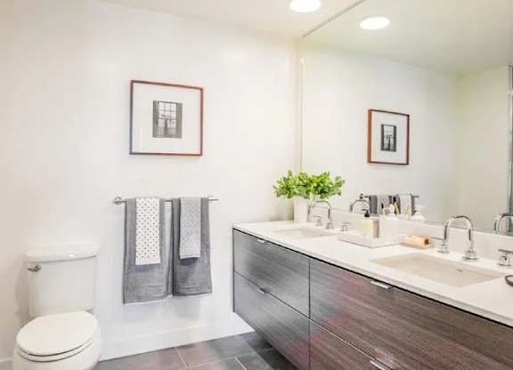 A bathroom with a toilet, sink, and mirror.at The Rise, California  