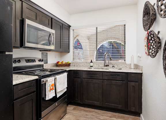 A kitchen with black cabinets and appliances.